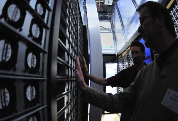 A technician beside dense server racks in a data center